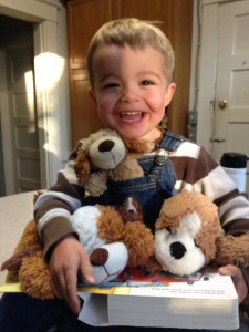 Ben with stuffed dogs, smiling 11-15